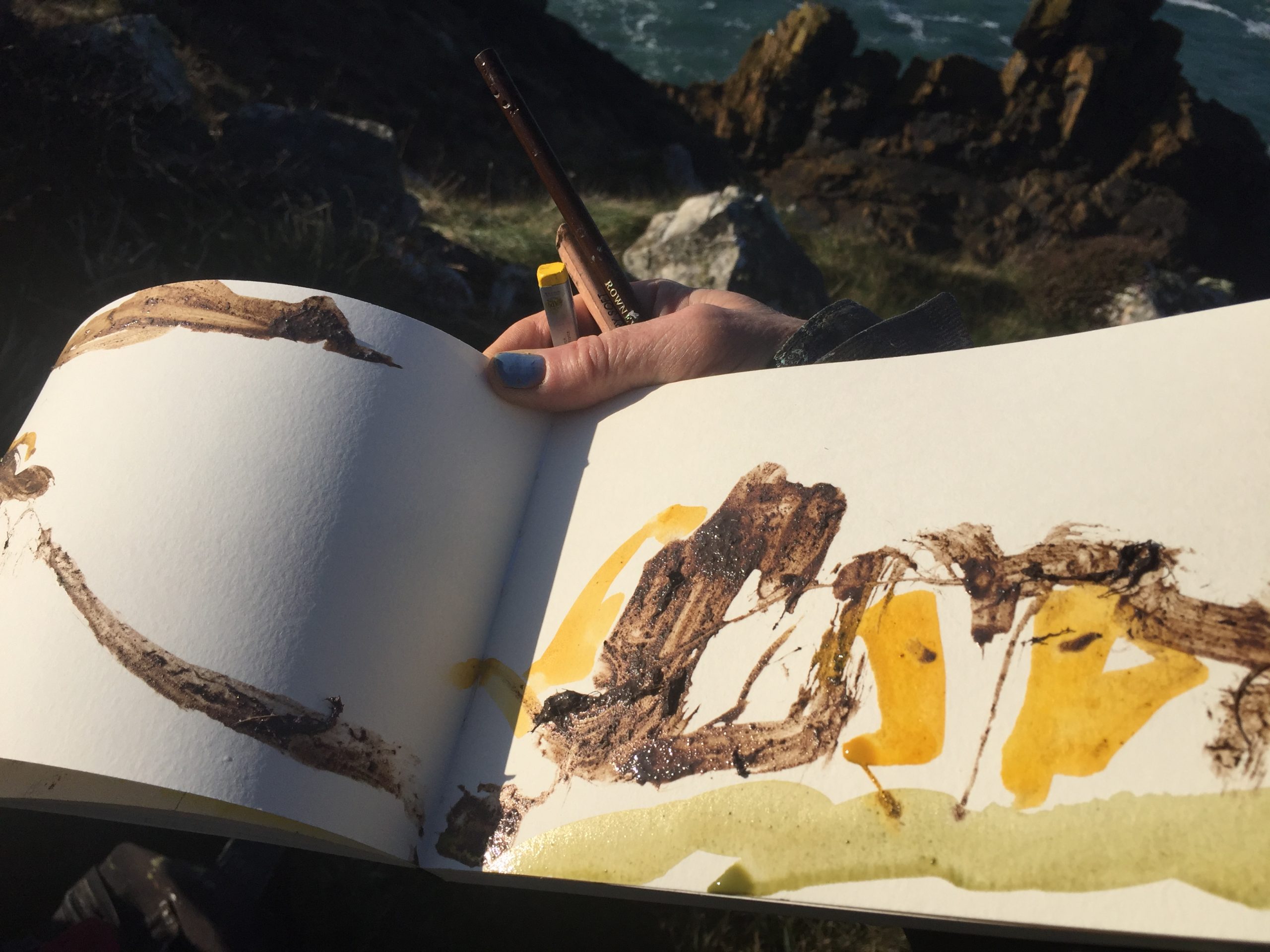 Straight into the book — Site earths, worked wet across the page.